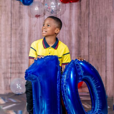 A Boy Holding Blue Balloons